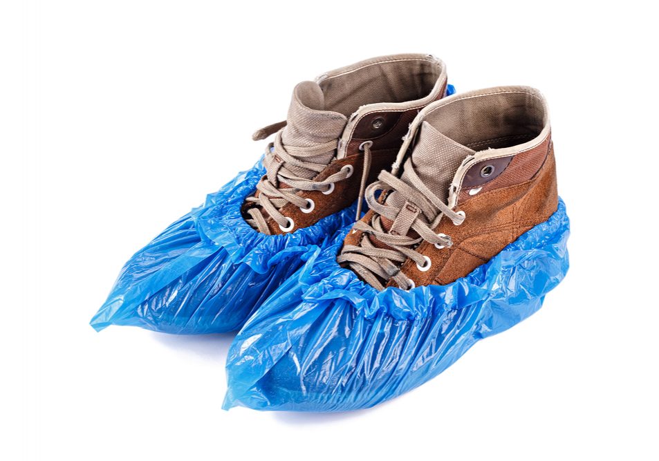 blue protective shoe covers on men's shoes isolated on white background