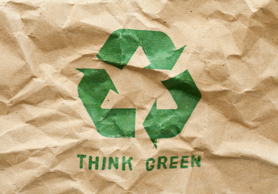 Green recycle symbol on crumpled cardboard